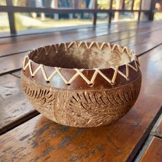 a brown bowl sitting on top of a wooden table