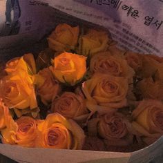 a bunch of yellow roses in a paper bag