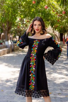 This Beautiful Dress boasts a Traditional Mexican floral design combined with a modern style dress. The embroidered bodice combined with the bell sleeves and lace make it fun and flirty. It's made out of fine Mexican cotton and has elastic around the top for an adjustable fit. This dress is handmade and embroidered by Mexican Artisans in Guanajuato, Mexico. Purchase the Men's Matching Guayabera here: https://www.etsy.com/es/listing/1184172577/guayabera-mexicana-bordado-floral-camisa?ref=listings Spanish Style Dress Classy, Mens Mexican Outfit, Mexican Dresses Traditional Embroidery, Mexican Jacket Outfit, Mexican Fiesta Dress, Modern Mexican Dress, Elegant Mexican Dresses For Women, Traditional Mexican Outfits For Women, Mexican Dresses Modern