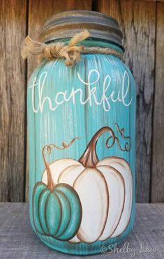 a painted mason jar with pumpkins on it