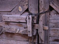 a close up of a wooden door with chains attached to it's outside wall