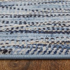 a blue and white rug on top of a wooden floor