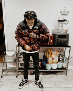 a young man standing in front of a shelf