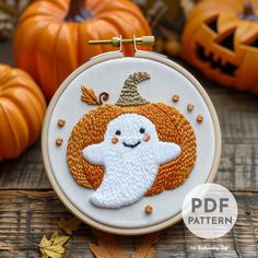 an embroidered halloween ghost with a pumpkin in the background