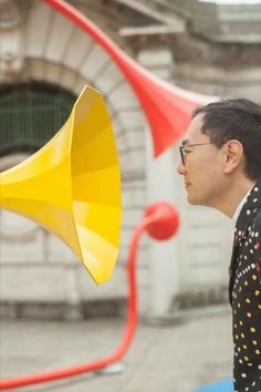 a man standing next to a yellow and red bullhorn