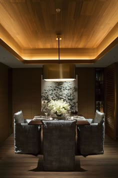 a dining room table with two chairs and a chandelier hanging from the ceiling