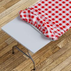 a red and white checkered table cloth sitting on top of a metal chair