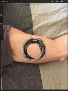 a man's arm with a tattoo on it that has a green circle in the middle