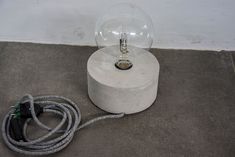 a light bulb sitting on the ground next to a cord