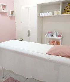 a white bed sitting in a bedroom next to a pink wall