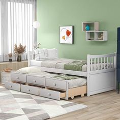 a twin bed with trundle drawers in a green walled children's room