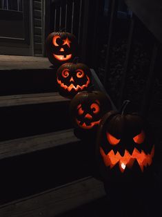 three carved jack o lantern pumpkins sitting on the steps