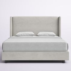 an upholstered bed with white linens and pillows