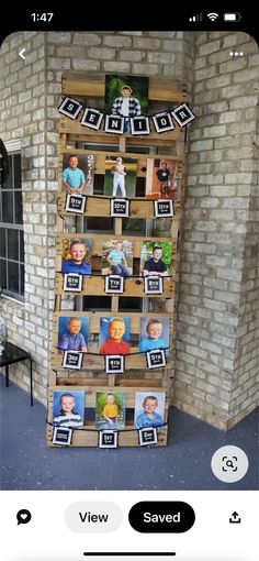 a tall wooden shelf with pictures on it in front of a brick wall and window