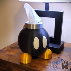 a tissue dispenser sitting on top of a wooden table next to a lamp