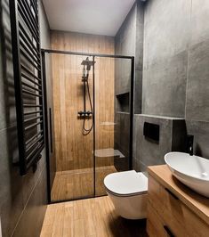 a bathroom with a toilet, sink and shower stall in it's own area