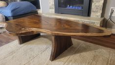 a wooden table sitting in front of a fire place on top of a carpeted floor