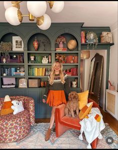 a woman sitting on a chair in front of a bookshelf with stuffed animals