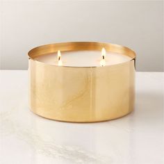 a gold candle holder with three lit candles