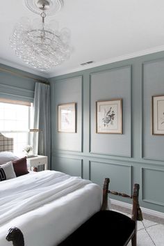 a bedroom with blue walls and white bedding