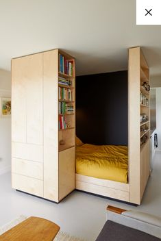 a room with a bed, bookshelf and cabinets in it that are open