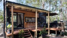 a small cabin with an outdoor kitchen on the deck