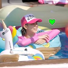 a woman in a pink hat is floating on an inflatable unicorn pool float