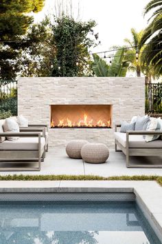 an outdoor fireplace with couches around it