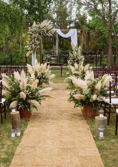 an outdoor ceremony setup with white flowers and greenery