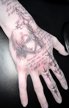 a person's hand with tattoos on it and writing all over the palm area