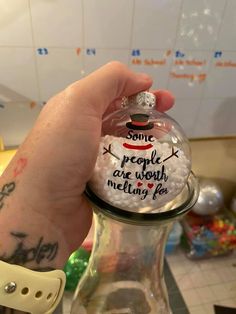 someone is holding up a snow globe with some writing on it and the ball has been put in it