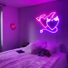 a bed in a room with a neon sign on the wall above it that says love