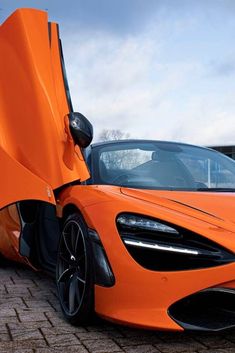 an orange sports car with its doors open