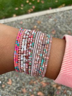 a close up of a person's arm wearing bracelets with beads on it