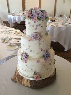 a three tiered wedding cake sitting on top of a white table cloth covered table