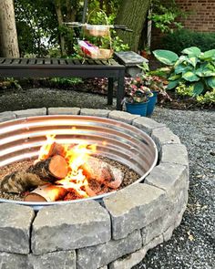 an outdoor fire pit with logs burning in it