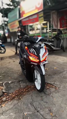 the motorcycle is parked on the side of the road in front of some people and motorcycles