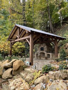 an outdoor fireplace surrounded by rocks and trees