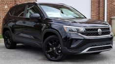 a black suv parked in front of a brick building