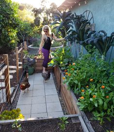 a woman standing in the middle of a garden