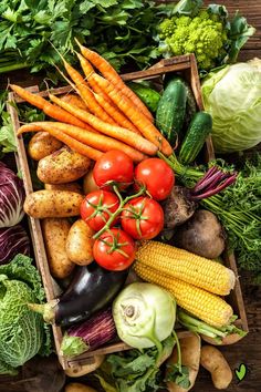 an assortment of fresh vegetables including carrots, corn, potatoes and broccoli