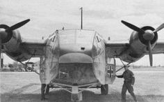 an old black and white photo of a man standing next to a plane