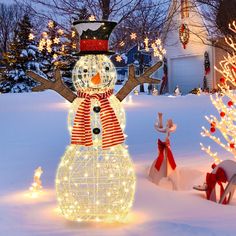 a lighted snowman in the middle of a yard