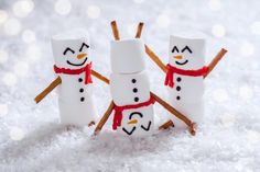 three marshmallow snowmen standing in the snow