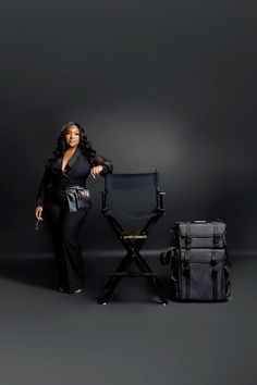 a woman standing next to a chair and luggage