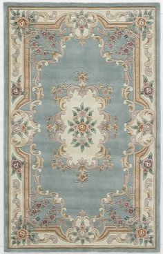 a blue rug with an ornate design on the center and sides, in various colors