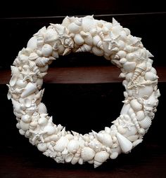 a wreath made out of seashells on a wooden surface