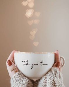 a woman holding a coffee cup with the words take your time written on it