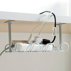 an electronic device is connected to wires and plugs on a shelf above a sink