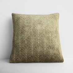 a gold pillow sitting on top of a white table